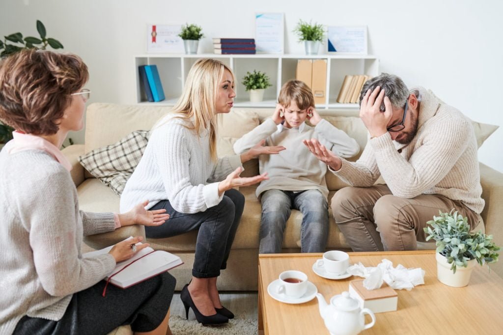 sad son covering ears while parents having quarrel at therapy se 1024x682 1